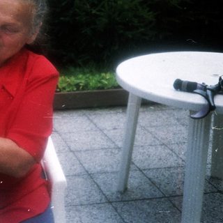 Woman tossing bread rolls outdoors.