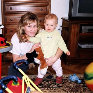 A woman holding a young child in a playful indoor setting.
