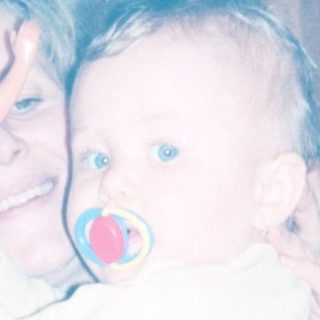 A woman holding a baby indoors.
