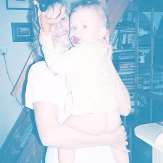 A woman holding a baby indoors.