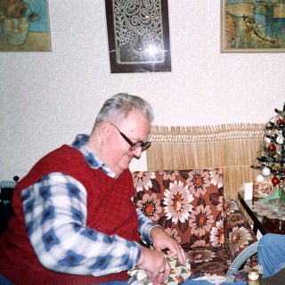 Two elderly people crafting together indoors.