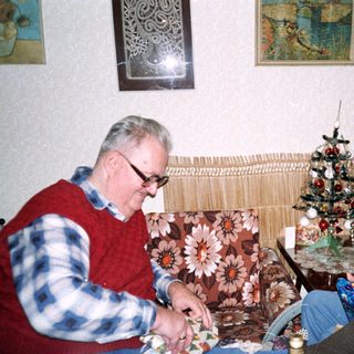 Two elderly people crafting together indoors.
