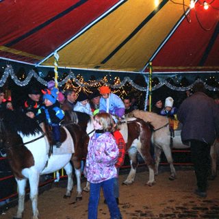 Pony ride tent with children and ponies.