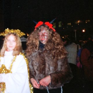 Christmas parade with bishop, angel, shepherd, and goat character.