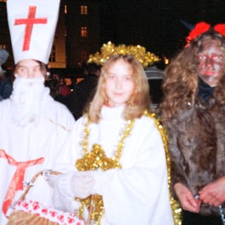 Christmas parade with bishop, angel, shepherd, and goat character.