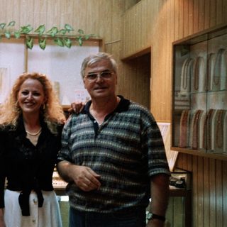 Three people posing indoors together in formal attire.
