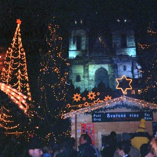 Christmas market scene with illuminated decorations and crowd.