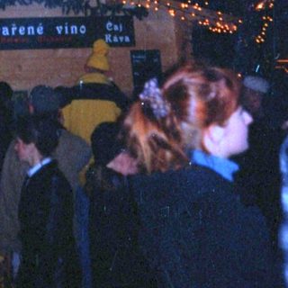 Christmas market scene with illuminated decorations and crowd.