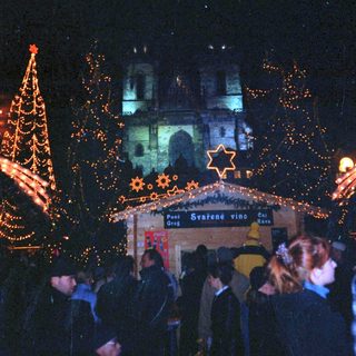 Christmas market scene with illuminated decorations and crowd.