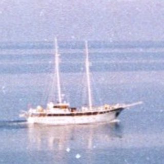 Coastal scene with sailboat on calm sea.