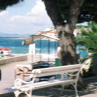 Person walking near seaside with beach umbrellas.