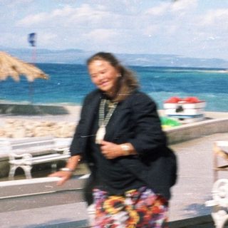 Person walking near seaside with beach umbrellas.