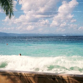 Person surfing in ocean waves near shore.
