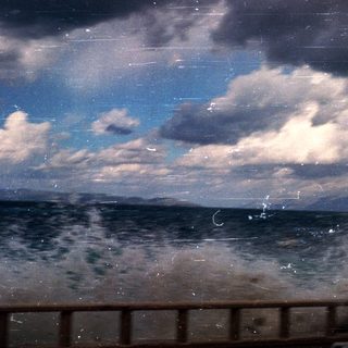 Ocean waves under stormy, cloudy sky.