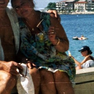 Happy couple posing by seaside promenade.