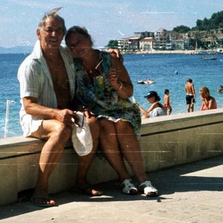 Happy couple posing by seaside promenade.