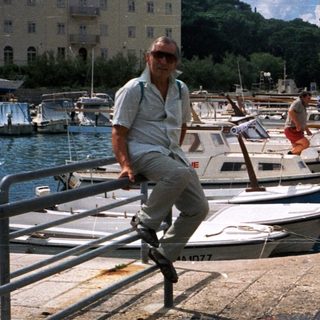 Marina dock with boats, man posing.