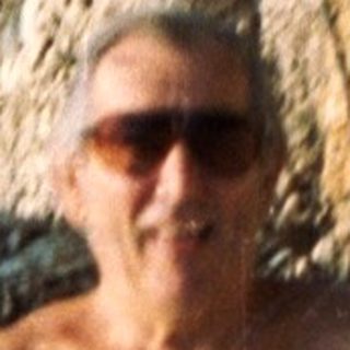 Shirtless person jumping into a waterfall.