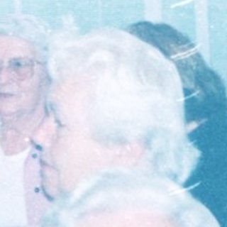 Group of elderly people gathered indoors in a communal setting.
