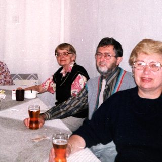 Group of five people enjoying drinks indoors.