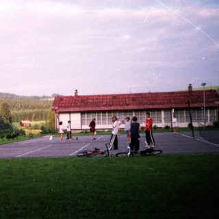 Residential area with people riding bikes and scooters.