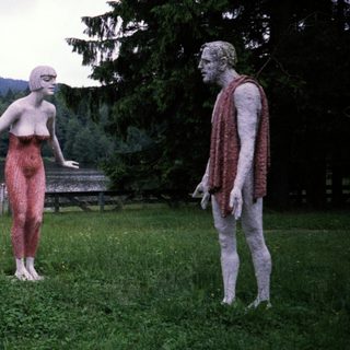 Three life-sized sculptures depicting human figures outdoors.