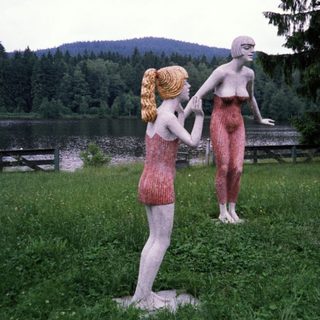 Three life-sized sculptures depicting human figures outdoors.