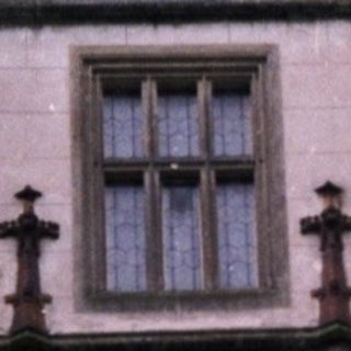 Gothic-style castle entrance with coat of arms.