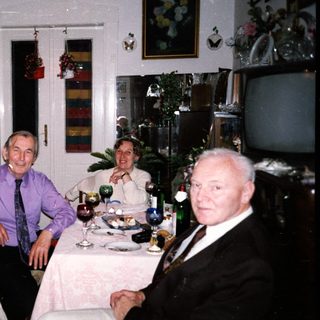 Four adults gathered indoors for a festive meal.