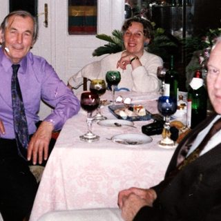 Four adults gathered indoors for a festive meal.