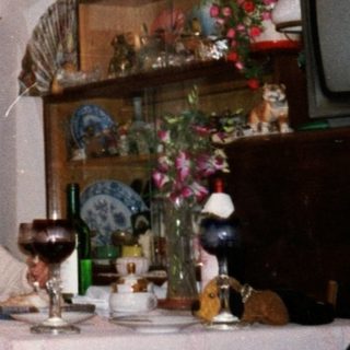 Family gathering enjoying drinks indoors during holiday season.