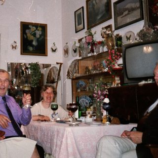 Family gathering enjoying drinks indoors during holiday season.