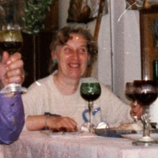Family gathering enjoying drinks indoors during holiday season.