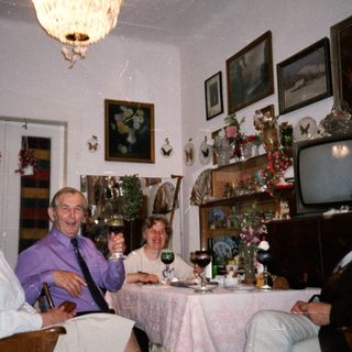 Family gathering enjoying drinks indoors during holiday season.