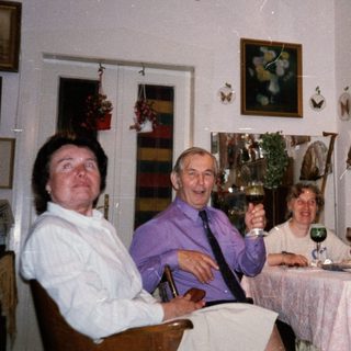 Family gathering enjoying drinks indoors during holiday season.