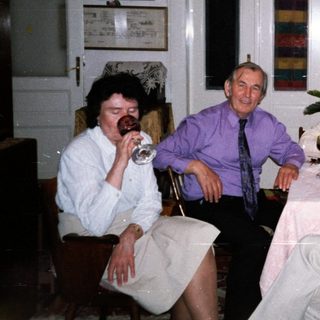 Four adults enjoying a meal and drinks indoors.