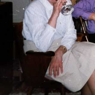 Four adults enjoying a meal and drinks indoors.