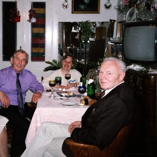 Four adults enjoying a meal and drinks indoors.