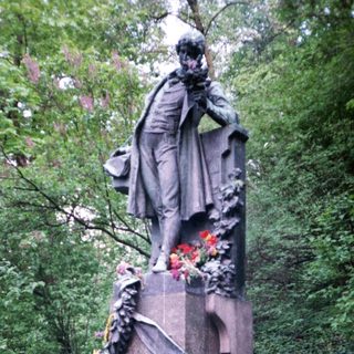 Man posing with floral wreath at historic monument.
