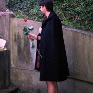 Statue honoring a historical figure with floral tributes.