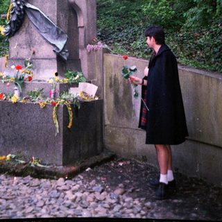 Statue honoring a historical figure with floral tributes.