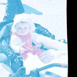 Baby in winter clothing seated in stroller outdoors.