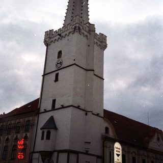 Historic town tower with clock and spire.