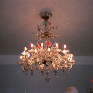 Elegant chandelier with lit candles indoors.