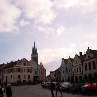 Historic European town square with old buildings and church tower.