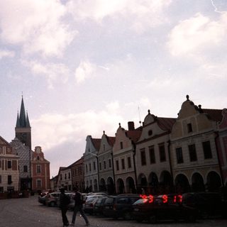 Historic European town square with old buildings and church tower.