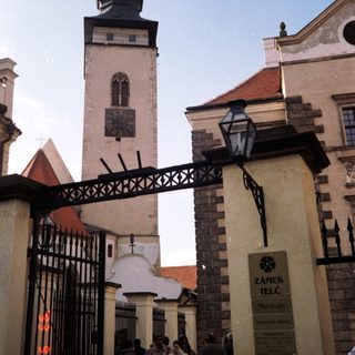 Historic castle entrance with tower and visitors.
