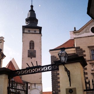 Historic castle entrance with tower and visitors.