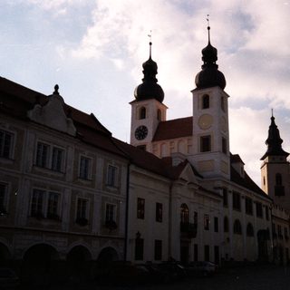 Historic European town square with church towers.