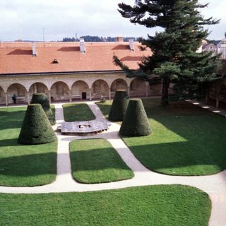 Elegant courtyard with arched cloister and manicured garden.